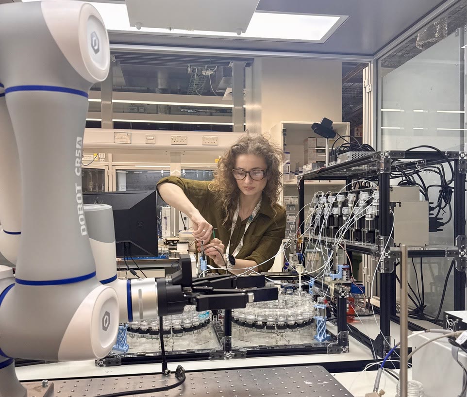 Melanie Guillén Soler working alongside a robotic laboratory platform
